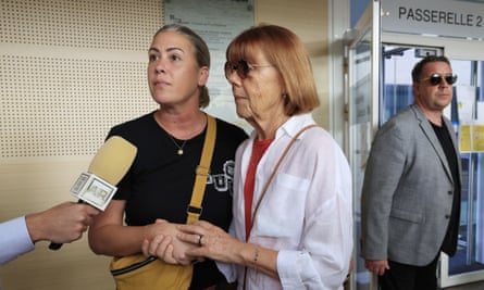 Gisèle Pelicot stands talking to someone with a microphone with a younger woman, with a younger man in the background