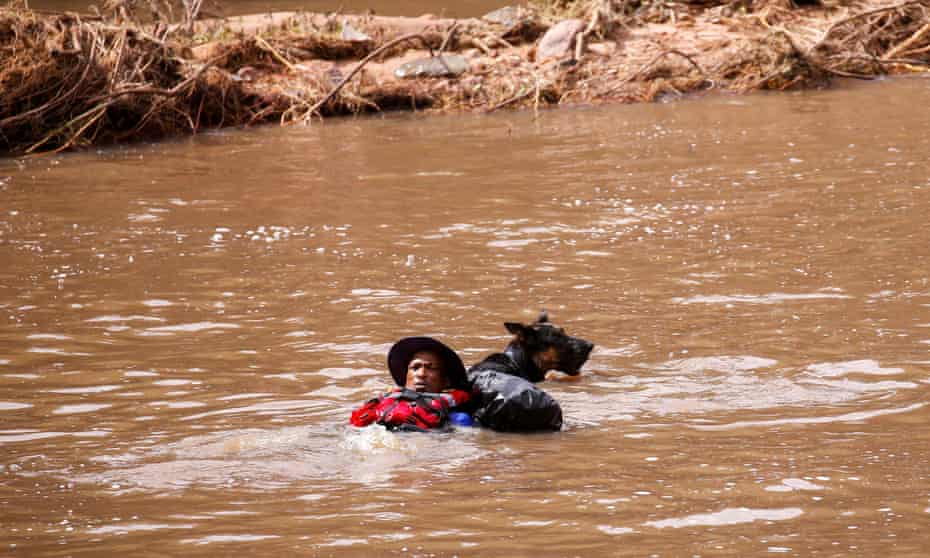 A search and rescue team member looks for bodies with the help of a dog, following torrential rains that triggered floods and mudslides, in Umbumbulu, near Durban, South Africa