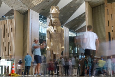 Motion blur image of tourists around a huge statue that is several times human height
