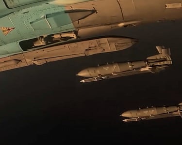 Close-up of the side of an Su-34 bomber and bombs falling from it