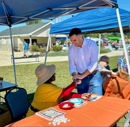 a man greets a woman who is seated at a table