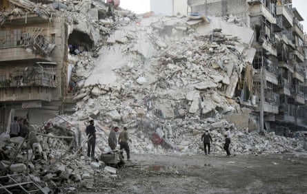 Members of the Syrian Civil Defence, known as the White Helmets, search for victims following airstrikes in Aleppo by Russian and Syrian warplanes.