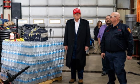 Former president Donald Trump stands next to a pallet of water before delivering remarks at the East Palestine fire department station in East Palestine, Ohio.