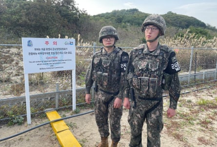 Two South Korean military police, part of an escort, stand at the Southern Limit Line on the barbed wire trail of the Goseong DMZ peace trail, just two kilometres away from North Korea.