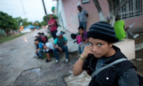 A 14-year-old Guatemalan girl traveling alone waits for a northbound freight train along with other Central American migrants, in 2014.