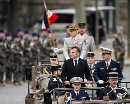 Fabien Mandon, standing to the right of Emmanuel Macron during a miltary parade.
