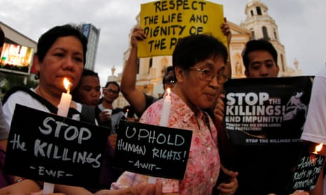 Filipino human rights advocates hold candles and placards during a candle light protest condemning recent extrajudicial killings in Manila, Philippines.