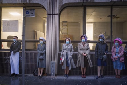 Extras wait outside in masks on the Liverpoool set