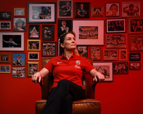 Lions Women head coach Jo Yapp sits in an armchair before a wall of framed sports photographs
