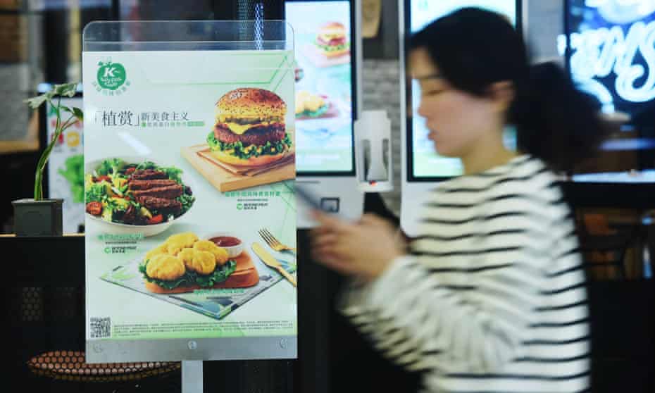 A person walks past an advertisement for plant-based products at a KFC store in Hangzhou