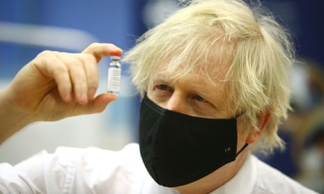 Boris Johnson with mask looks at vaccine vial