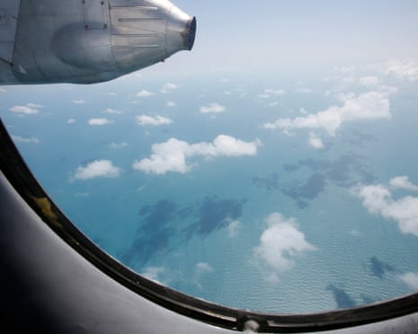 Clouds hover outside the window of an aircraft on a mission to find the missing Malaysia Airlines flight MH370