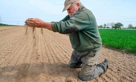 Farmer Roland Hild demonstrates the dryness of his field in Poppenweiler, Germany, in April 2020.