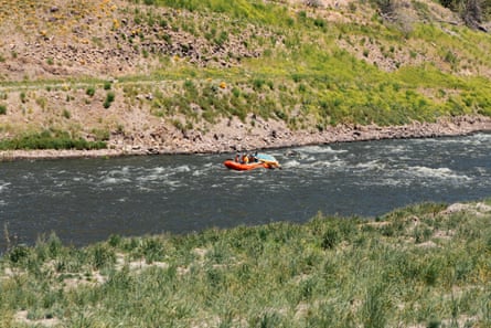 People ride along a river in a raft