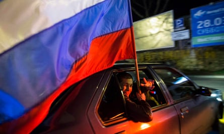 Man holding a Russian flag during the celebrations for the first anniversary of the annexation of Crimea in Sevastopol.