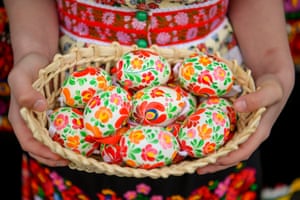 woman holding tray of decorated easter eggs