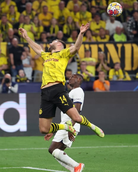 Dortmund's Niclas Füllkrug (left) reacts after a challenge by Nuno Mendes of PSG (right).