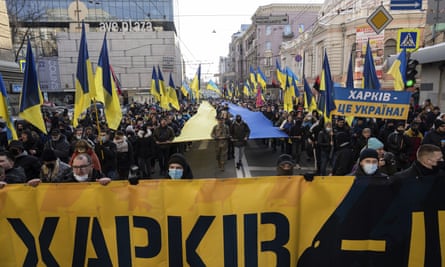 Demonstrators holding Ukrainian national flags march in Kharkiv, 5 February