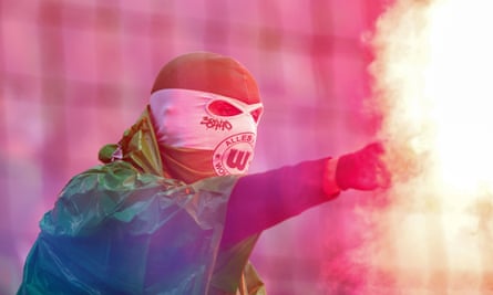 A Wolfsburg fan with a flare in the away end at St Pauli.