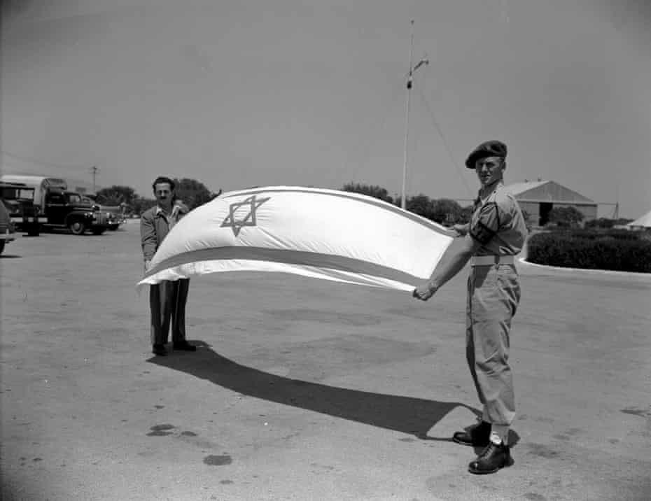 A soldier hoisting the new Israeli flag at Haifa airport in May 1948.