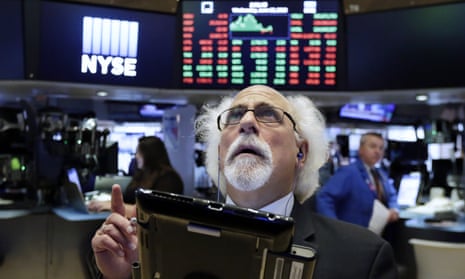 Trader Peter Tuchman watches screens on the floor of the New York Stock Exchange after the rate decision on Wednesday in New York, New York.