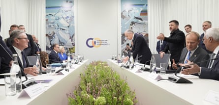 Leaders including Keir Starmer and Donald Tusk seated at two long tables facing one another, while Volodymyr Zelenskyy stands and speaks
