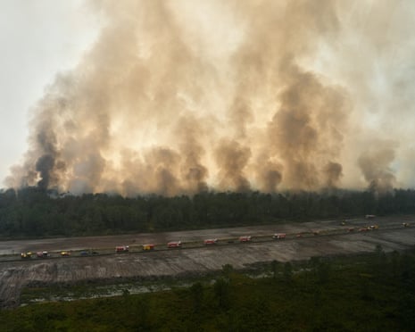 This aerial view taken from a Civil Security helicopter shows firefighting vehicles lined up along a road to suppress a wildfire near Ares, southwestern France.
