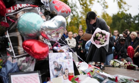 Fans lay flowers at a tribute in Hyde Park in London.