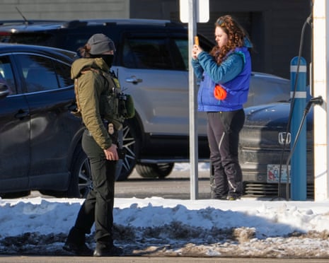 A woman films a homeland security agent at a parking lot at Deering Oaks Park, in Portland, Maine, 23 January 2026.