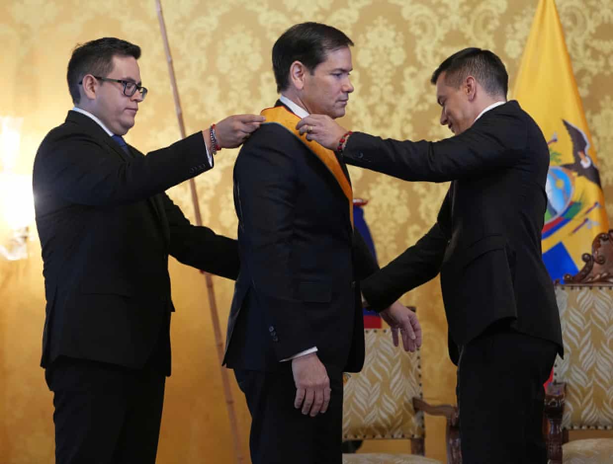 Two men put a metal on a third man in the center