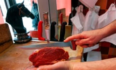 A French butcher prepares horsemeat on a block in a horse butchery shop in Marseille.