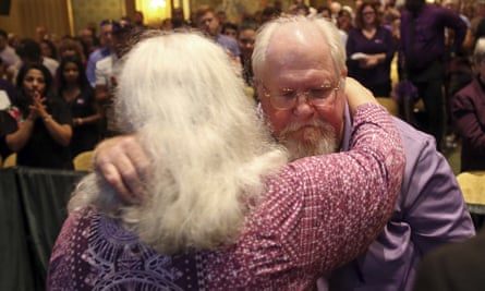Susan Bro and Mark Heyer embrace during a memorial for their daughter.