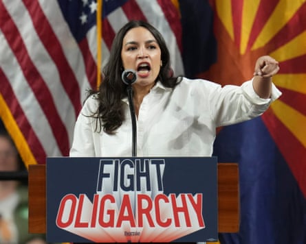 Alexandria Ocasio-Cortez at a podium beneath the sign 'fight oligarchy'