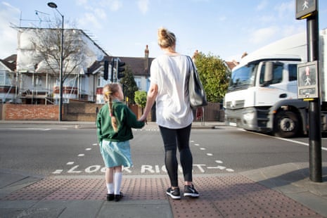 Children stand nearby a busy road with air pollution from trucks .