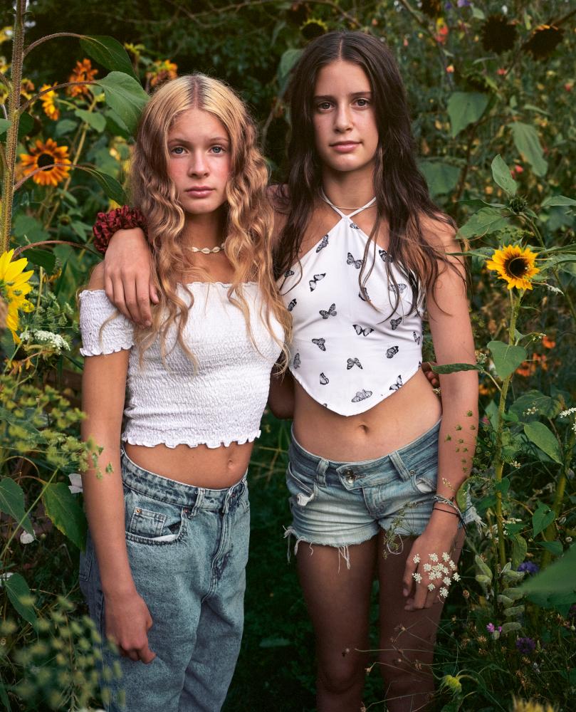 Two girls standing side by side in the garden