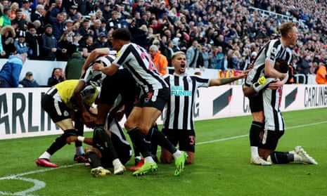 Joe Willock celebrates with his Newcastle teammates after his breakthrough goal against Manchester United