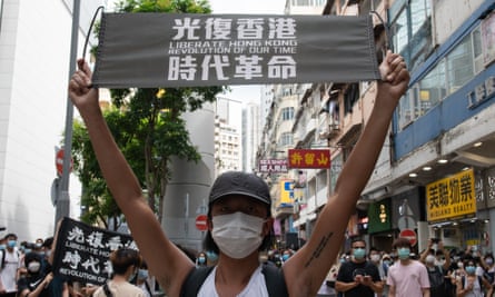 A protester holding a banner reading ‘Liberate Hong Kong: revolution of our time’