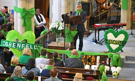 Sadiq Khan speaking at a large church decorated with green heart symbols and Grenfell memorial banners