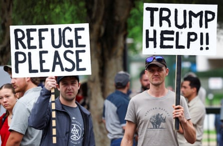 Demonstrators outside the US embassy in Pretoria, South Africa, with banners saying 'Refuge please' and 'Trump help!!'
