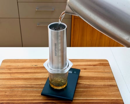 A person making coffee with an aeropress steel