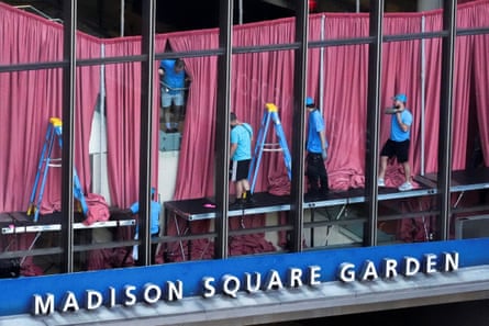 Workers set up pink curtains under a sign for Madison Square Garden