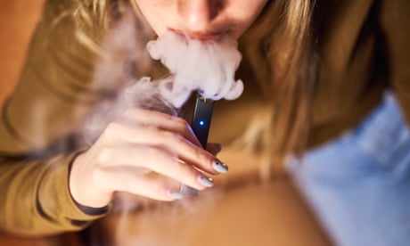 A person smokes an e-cigarette