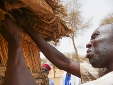 A Droum farmer opens his millet store.