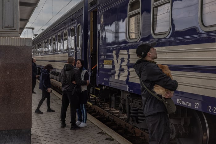 A woman shares a tender moment with a man before she boards a train heading to the west of Ukraine, at the railway station in Kharkiv, northeast Ukraine.