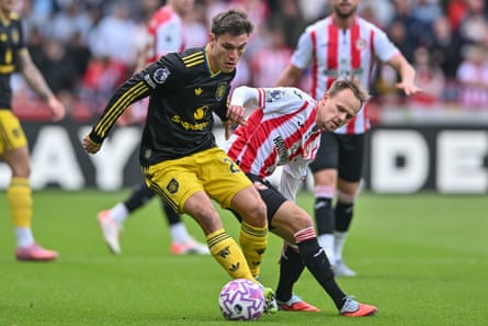 Manuel Ugarte holds off Brentford's Mikkel Damsgaard.
