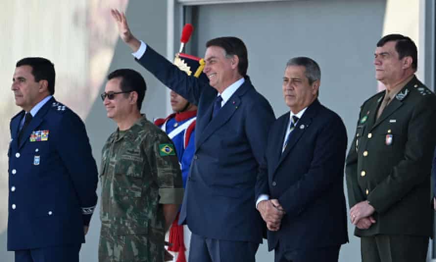 Jair Bolsonaro (centro) acena enquanto o show passa.