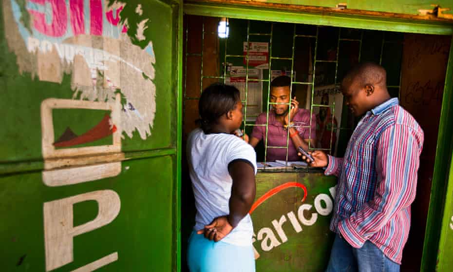 Residents transfer money using the M-Pesa banking service at a store in Nairobi, Kenya.