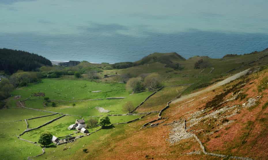 cottage on hillside with sea beyond