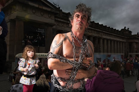 Escapologist and magician Tony Roberts puts on a show in front of the National Galleries on the Mound.