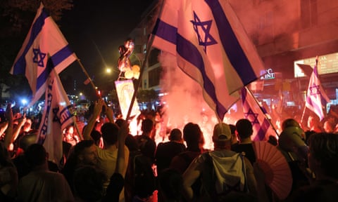 Relatives and supporters of Israelis taken hostage on 7 October light flares during a protest in Tel Aviv on 22 June calling for their release.